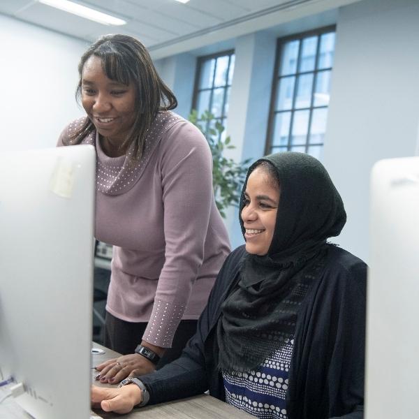 两个女学生一起在电脑前工作